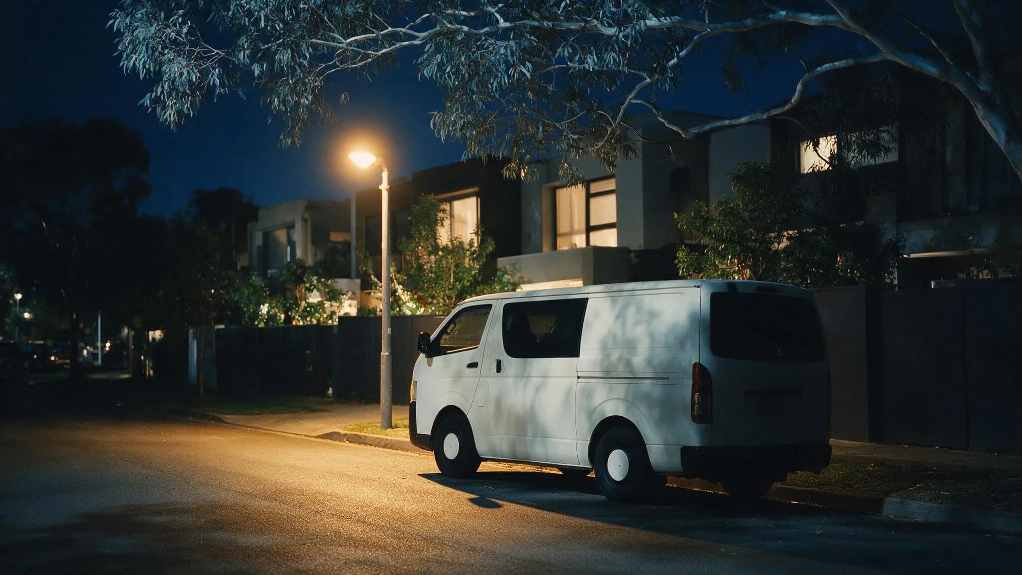 Tradesman walking toward a contemporary Melbourne townhouse at dawn