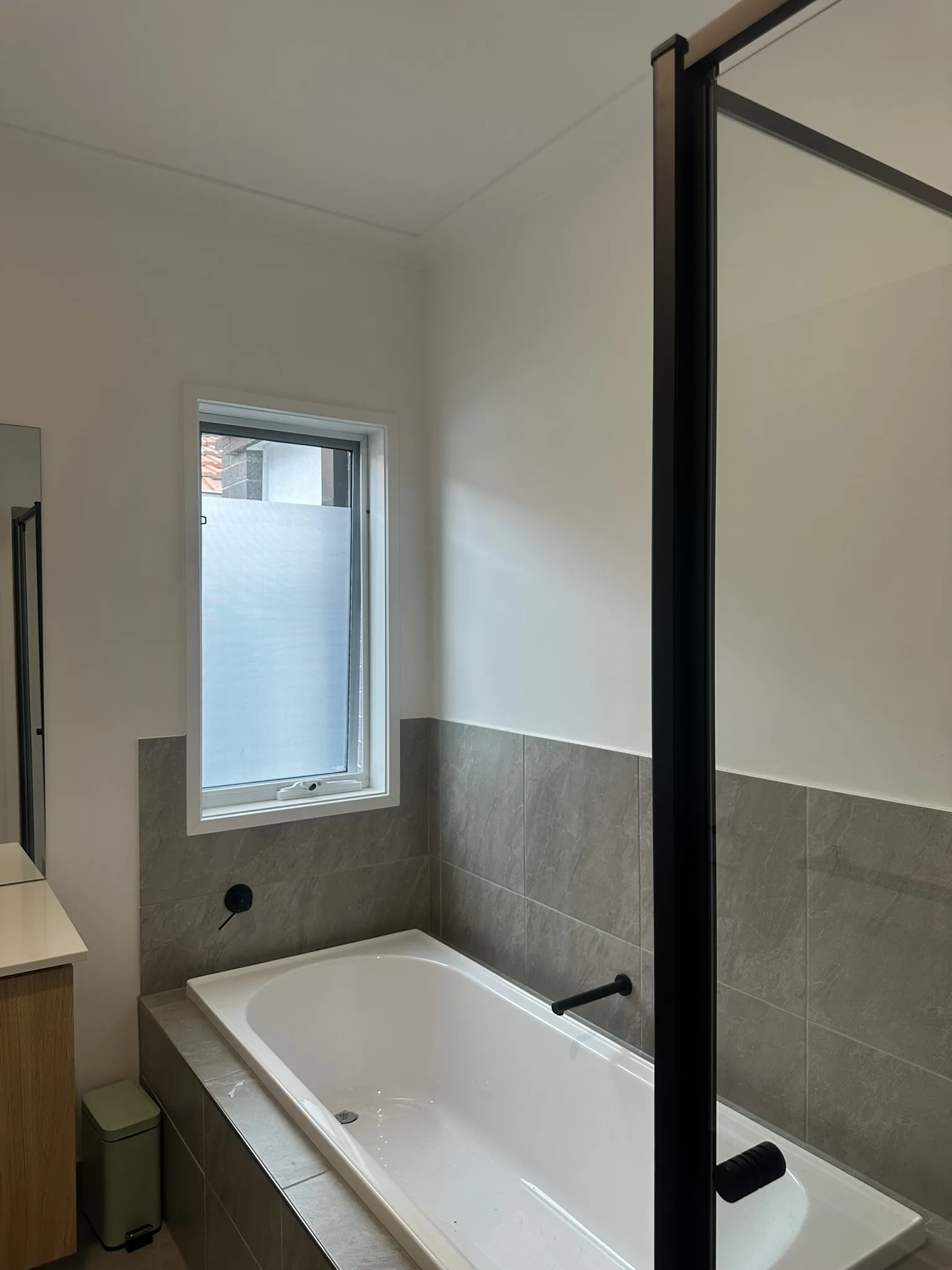 Partial frosted film installed to bathroom windows, providing privacy at eye level while allowing natural light to flow through the upper pane.