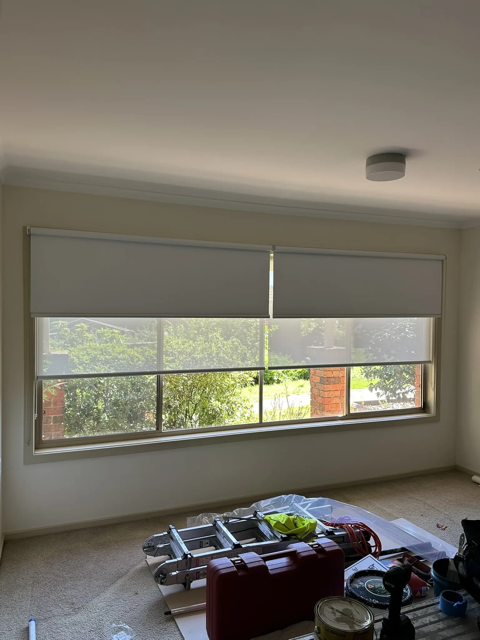 Double roller blinds installed throughout a freshly renovated home with frosted film applied to the front door sidelights, completing the renovation with layered light control and entry privacy.