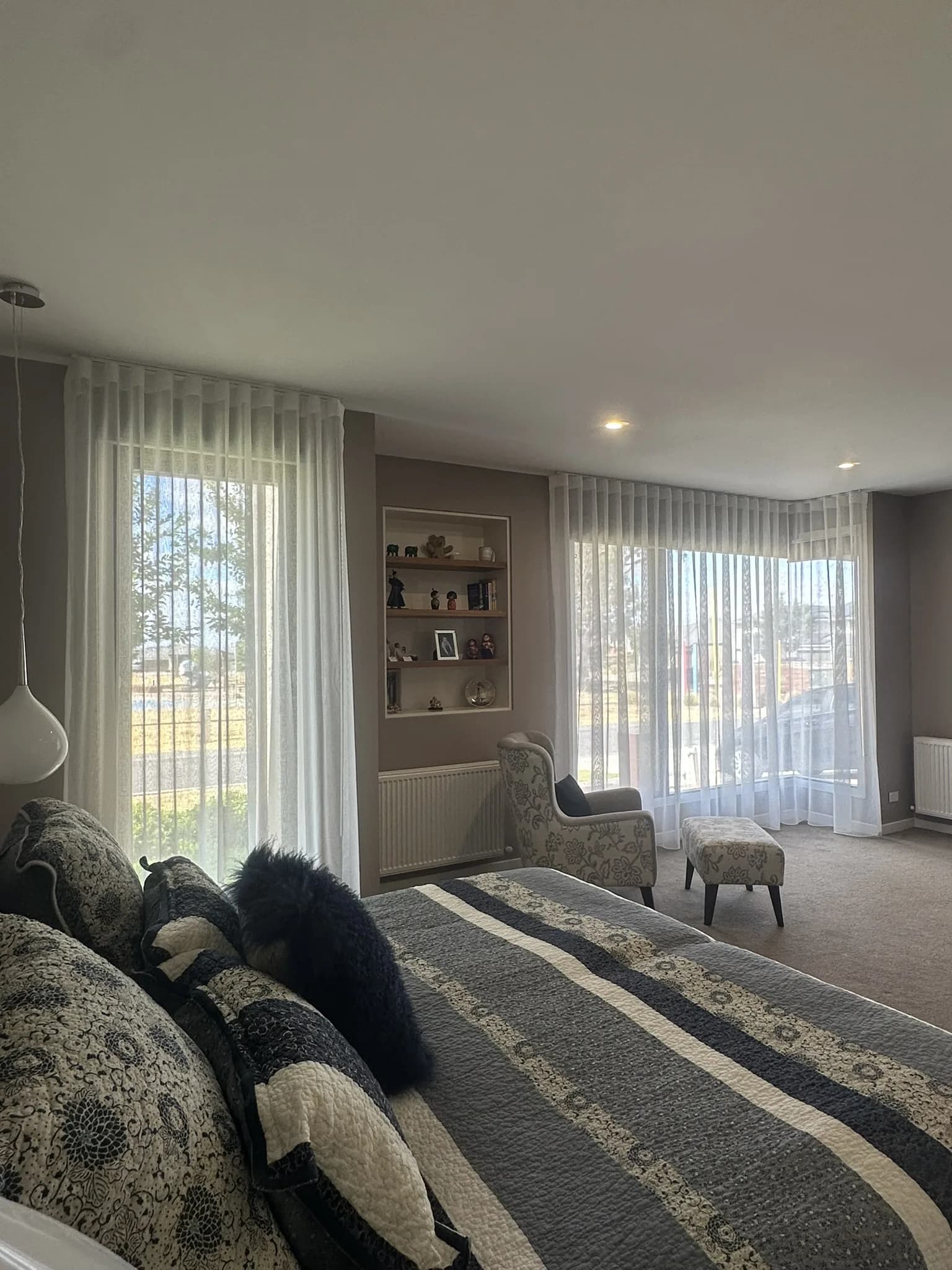 Roller blinds and custom ceiling-mounted sheers supplied and installed in a park-facing master bedroom to improve privacy, soften light and add value before sale.